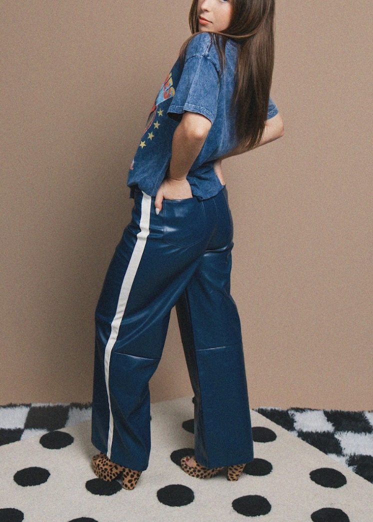 Person wearing a blue t-shirt and pants with white stripes on a checkered floor.