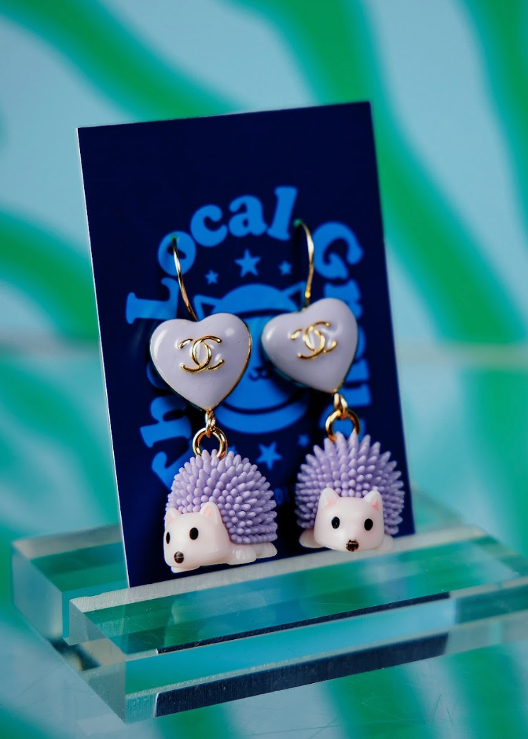 Heart-shaped earrings with hedgehog designs on a blue card with 'Local Group' branding.