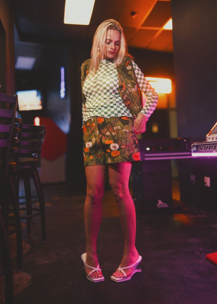 Woman in a colorful outfit standing in a bar setting