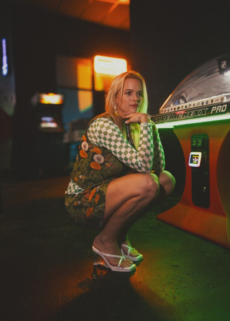 Woman in a colorful outfit sitting in a bar setting