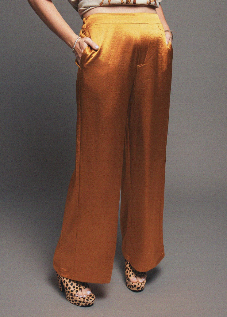 Person wearing mustard yellow wide-leg pants on a gray background