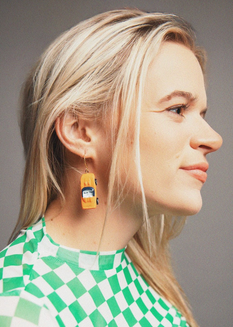 Woman wearing yellow earrings with a gray background