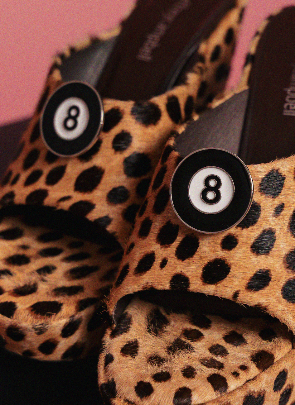 Leopard print shoes with number 8 clips on a pink background