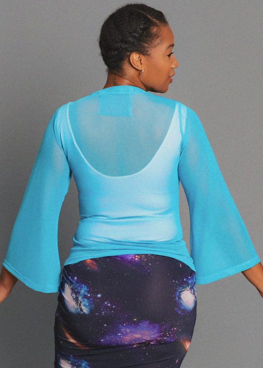 Person wearing a blue bell sleeve sheer top against grey background