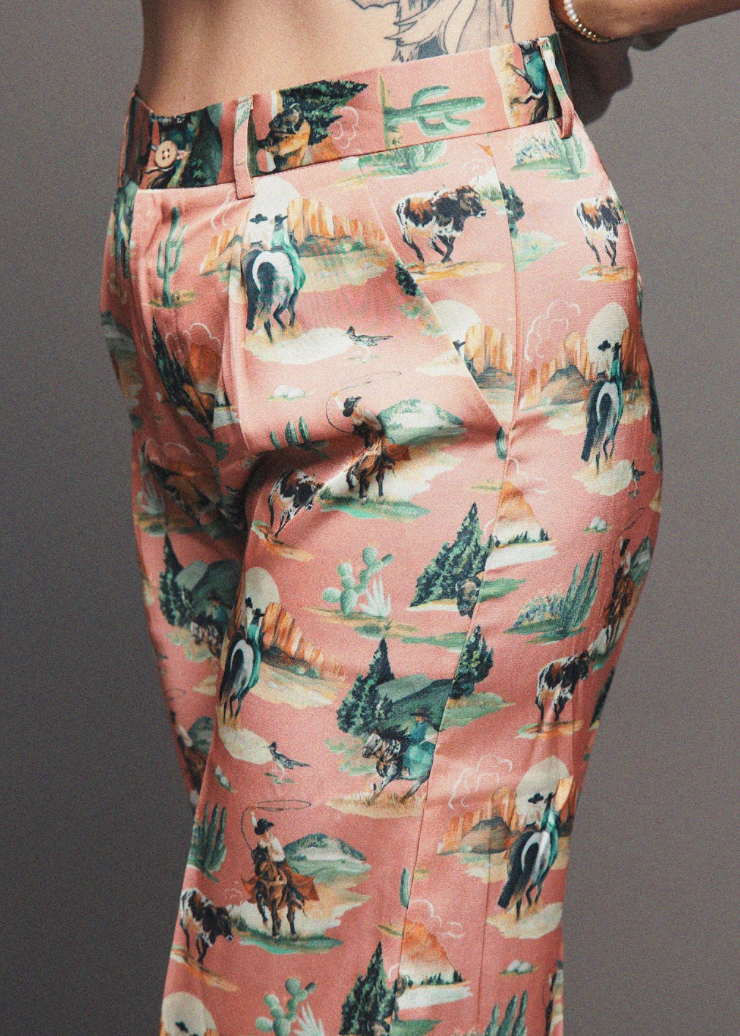 Pants with a cowboy-themed pattern on a plain background