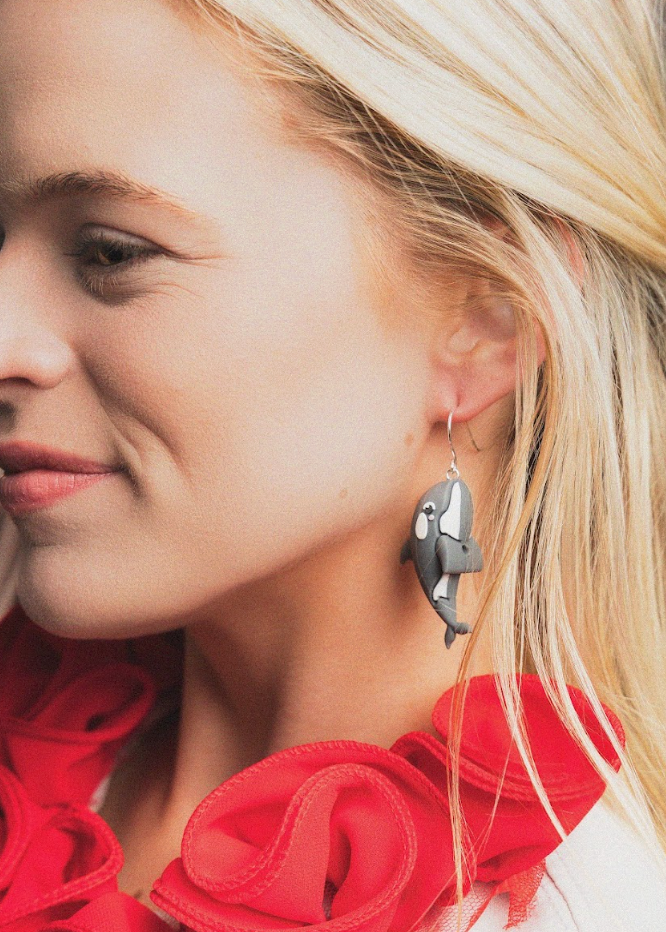 Close-up of a woman wearing a red scarf and earrings with a neutral background