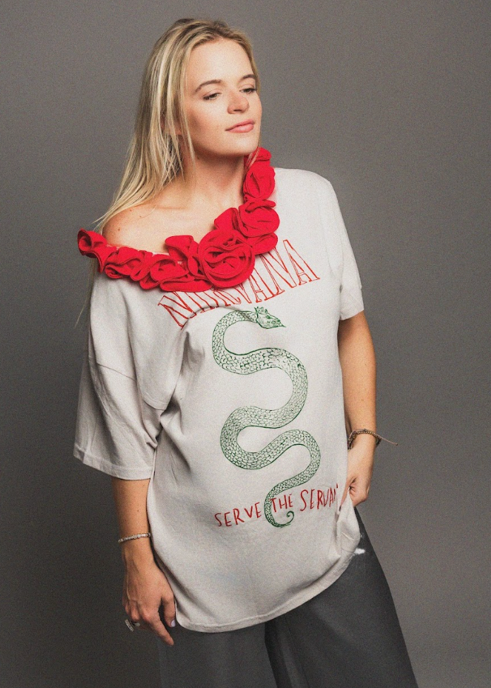 Woman wearing a gray t-shirt with a snake graphic and text, paired with a red scarf.
