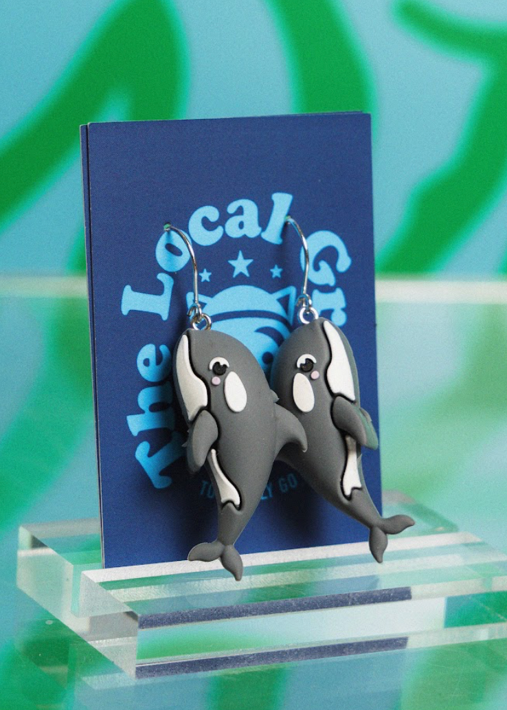 Orca whale earrings on a stand with a blue card in the background