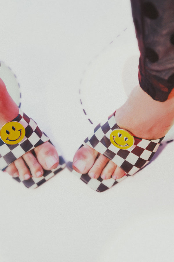 Checkered sandals with smiley face design on a white background