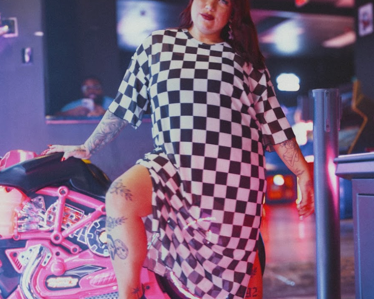 Person wearing a checkerprint dress in arcade setting