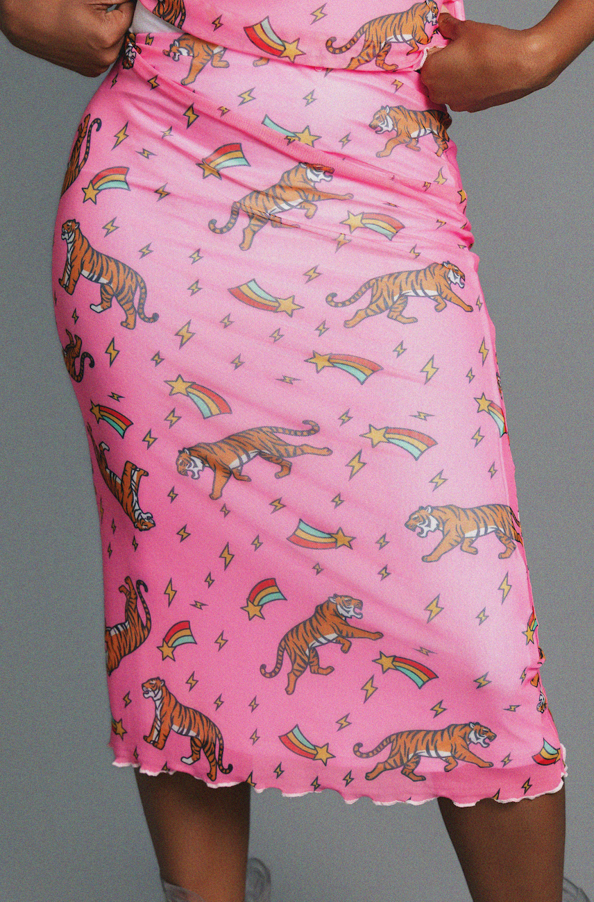 Pink skirt with tiger and rainbow pattern worn by a person on a gray background