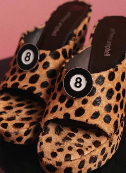 Leopard print shoes with number 8 clips on a pink background