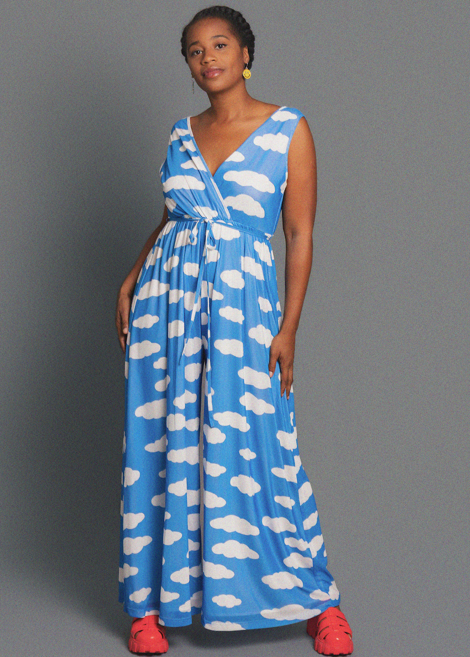 Woman wearing a blue dress with white cloud pattern against a gray background