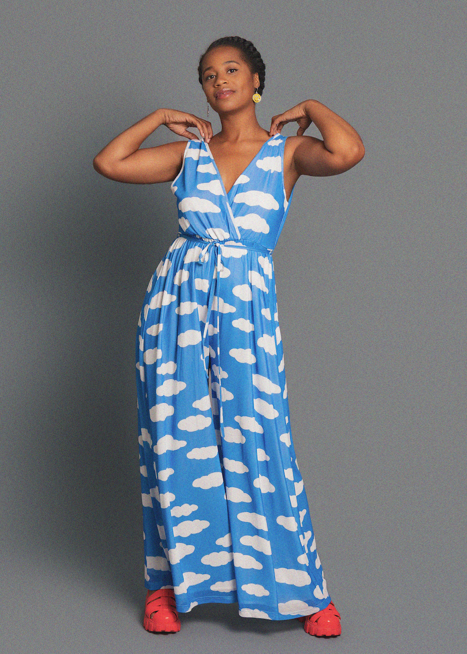 Woman wearing a blue dress with white cloud pattern on a gray background