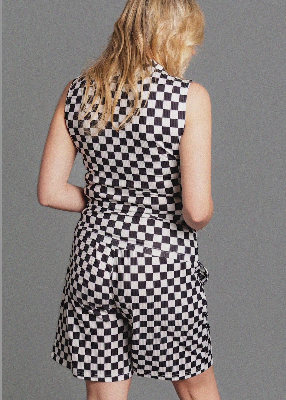 Person wearing a black and white checkered set against a gray background