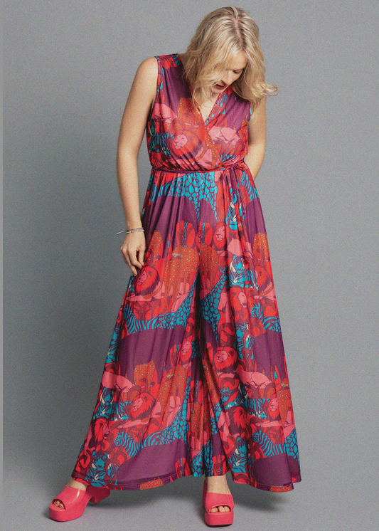 Woman wearing a colorful floral jumpsuit on a gray background